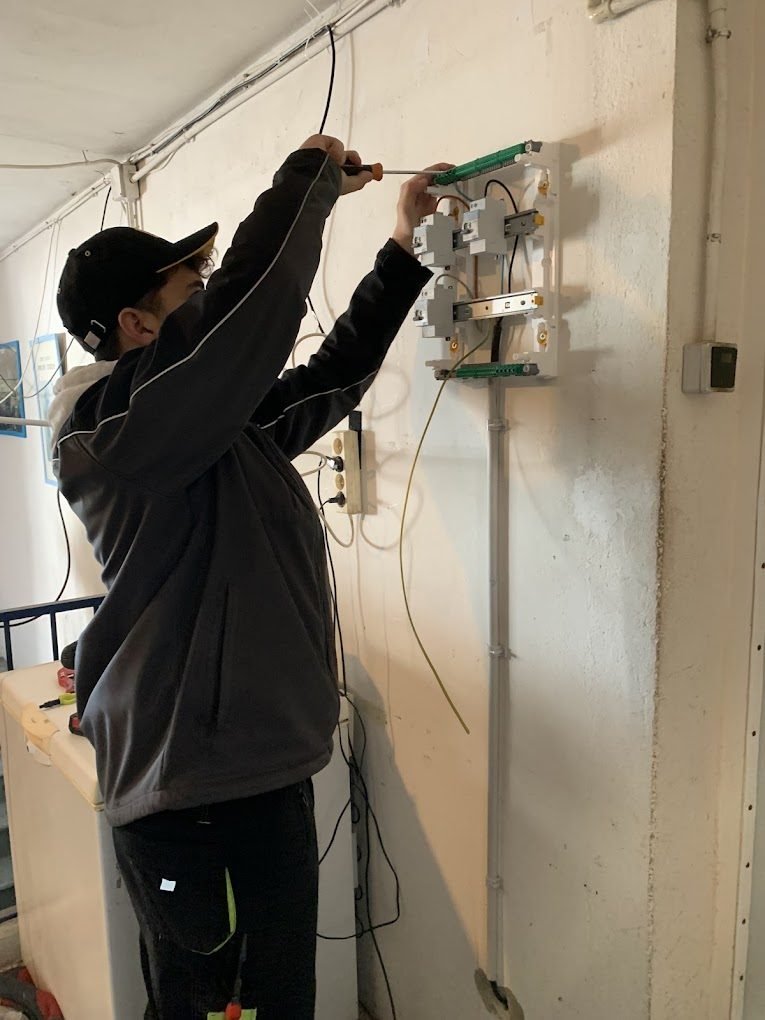 Électricien TorresElecMS raccordant un ensemble d'appareillage mural et son alimentation dédiée